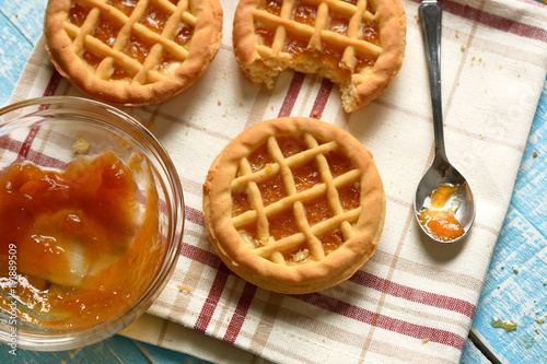 small pies with ingredients around on light blue table