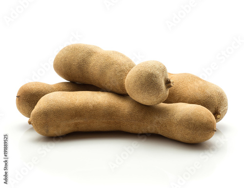 Tamarind isolated on white background three Indian dates in a brown brittle shell. photo