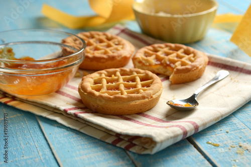 small pies with ingredients around on light blue table