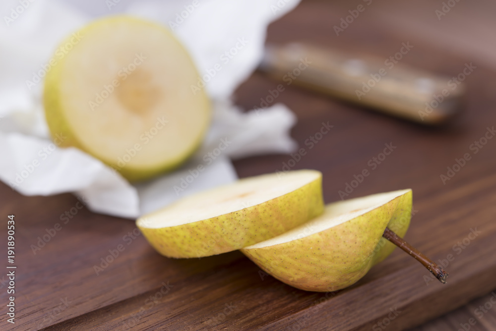Yellow cutting pear on a wooden board  and a knife