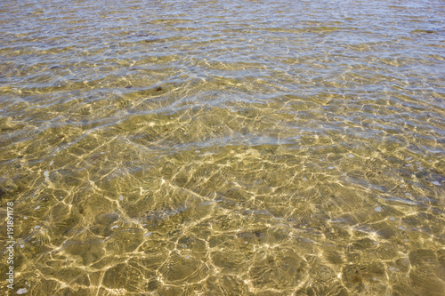 Texture of transparent sea waves in sunlight