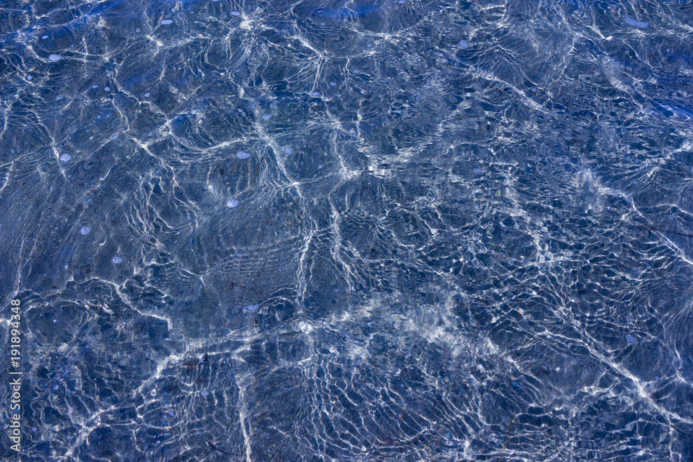Texture of transparent sea waves in sunlight Texture of transparent sea waves in sunlight