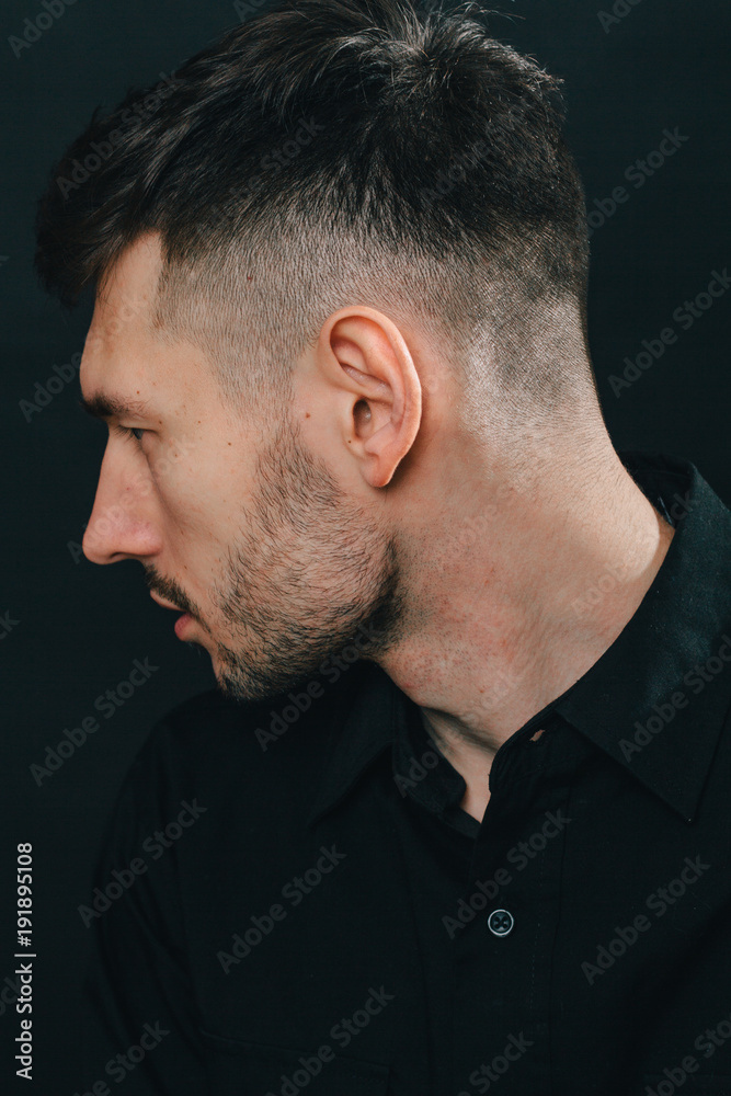 Obraz premium Man in headphones and black shirt on a black background