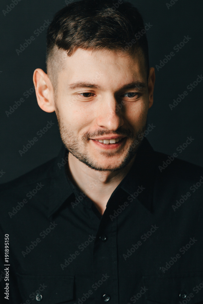 Fototapeta premium Man in headphones and black shirt on a black background
