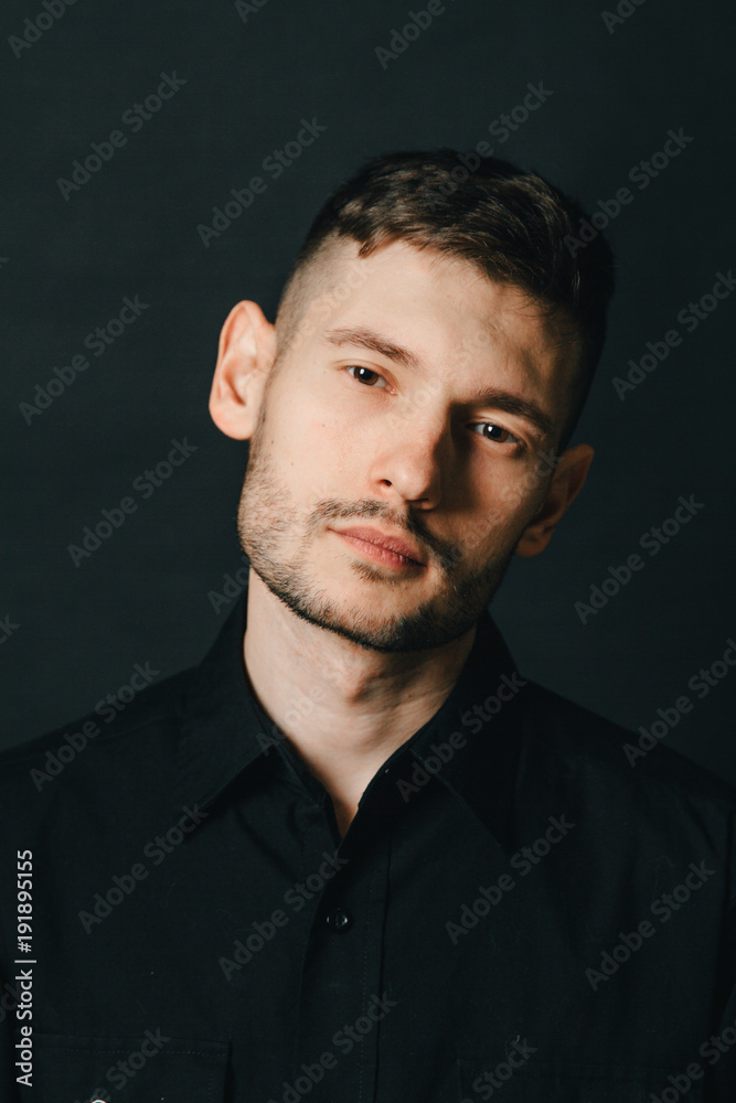 Man in headphones and black shirt on a black background