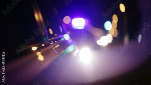 Police lights flashing in side view mirror of car