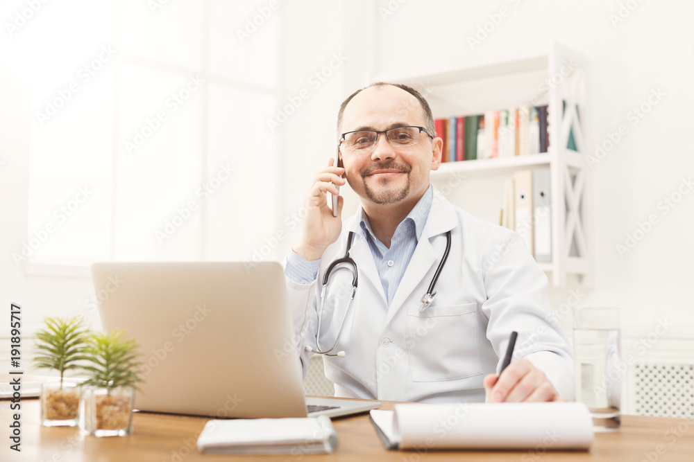 Happy doctor talking on the phone with his patient