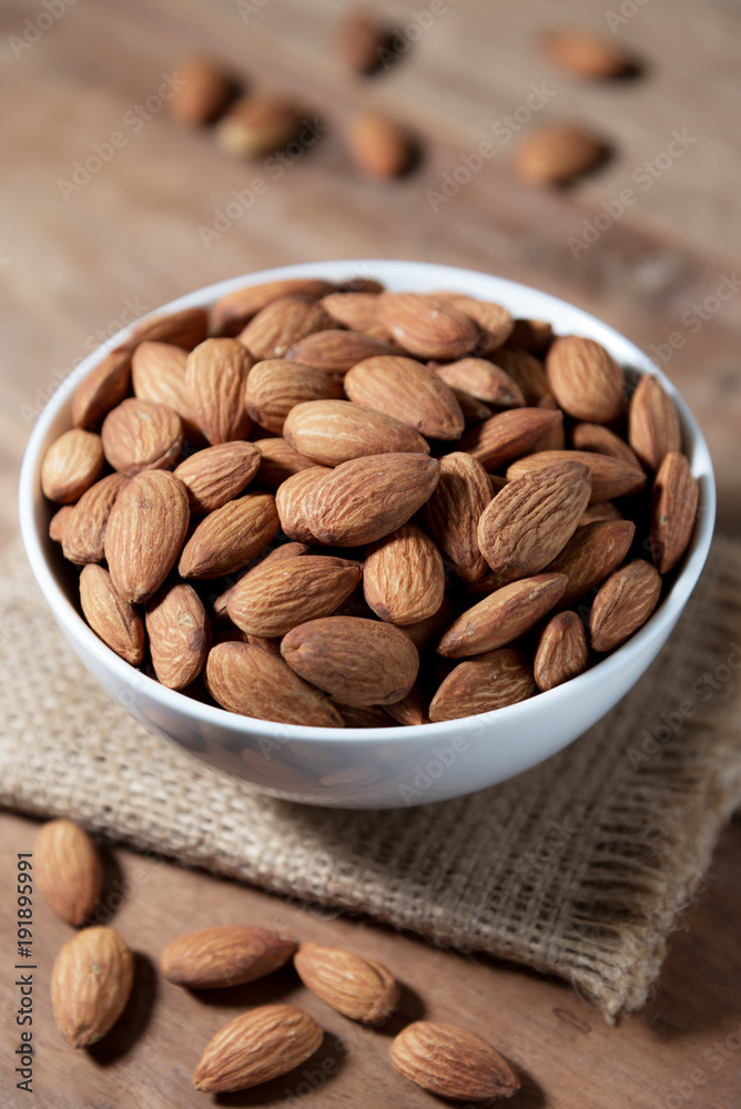 Almond snack fruit in white bowl on wooden Almond snack fruit in white bowl on wooden