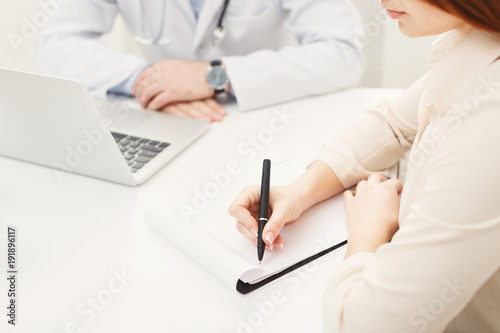Patient writing data to notebook, closeup