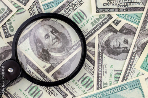 Fotografie Magnifying glass on 100 dollar bill background