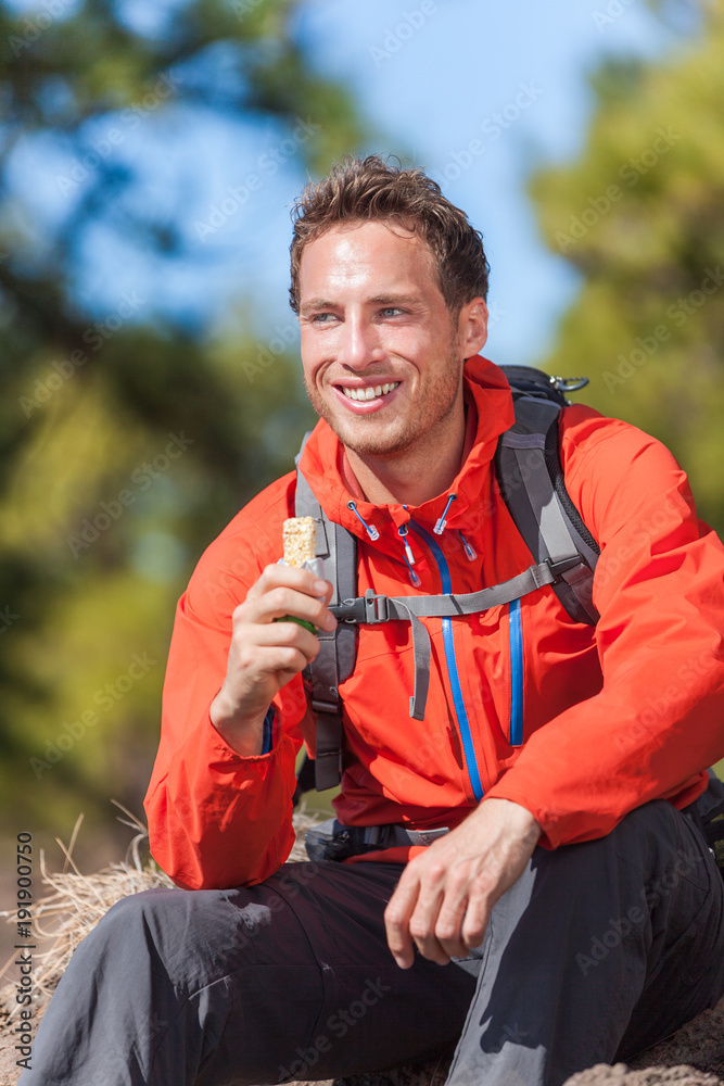 Hiker man healthy outdoor lifestyle eating muesli bar during hike on  mountain hiking. Happy people eat granola cereal bar snack living active  lifestyle in nature. Stock Photo | Adobe Stock