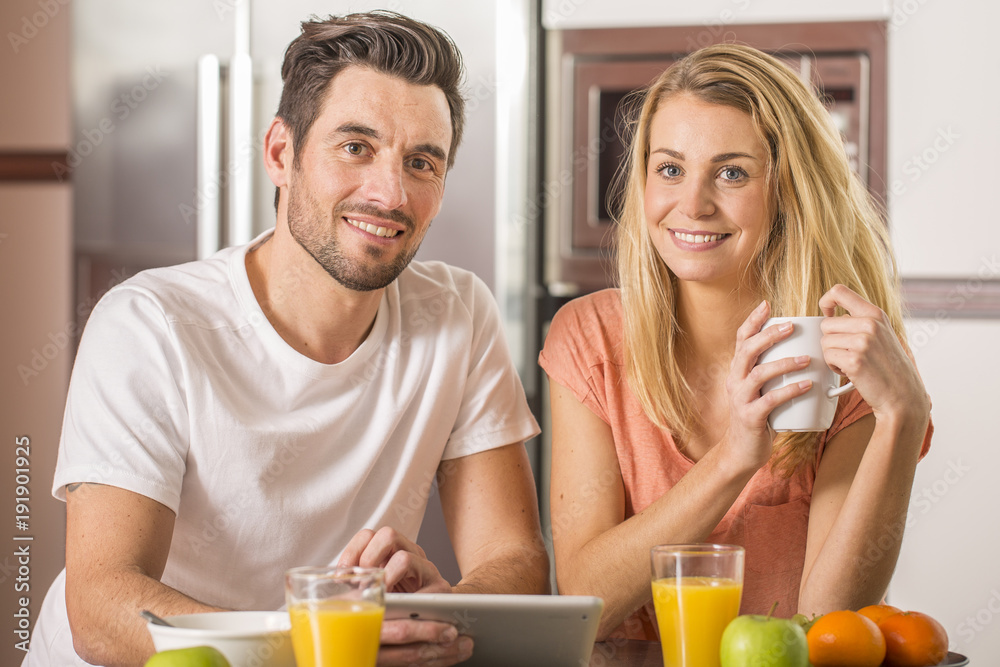 young couple using digital tablet at breakfast time young couple using digital tablet at breakfast time