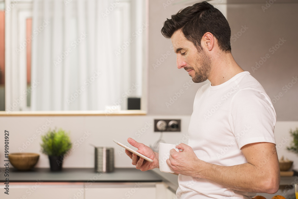 young man in home kitchen with tablet young man in home kitchen with tablet