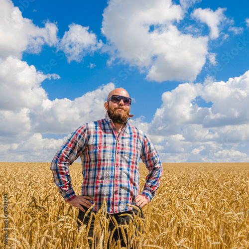 hairless farmer in glasses standing in a wheat field and talking on phone © valerii kalantai
