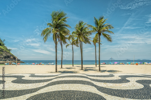 Palms on Copacabana Beach and landmark mosaic in Rio de Janeiro, Brazil. Sunny day with blue sky