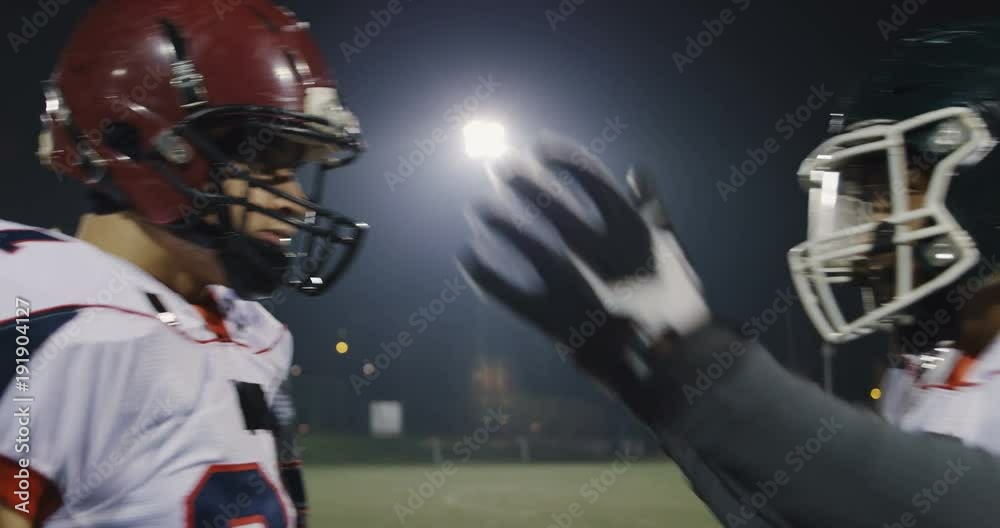 American football players knocking with helmets and having fun American football players knocking with helmets and having fun