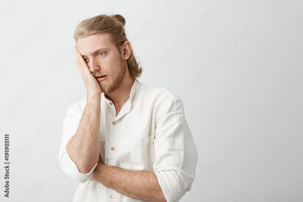 Studio portrait of handsome blond bearded man making face palm with annoyed or tired expression, standing against gray background. Guy wonders how can somebody be so dumb. Advertisement concept Studio portrait of handsome blond bearded man making face palm with annoyed or tired expression, standing against gray background. Guy wonders how can somebody be so dumb. Advertisement concept