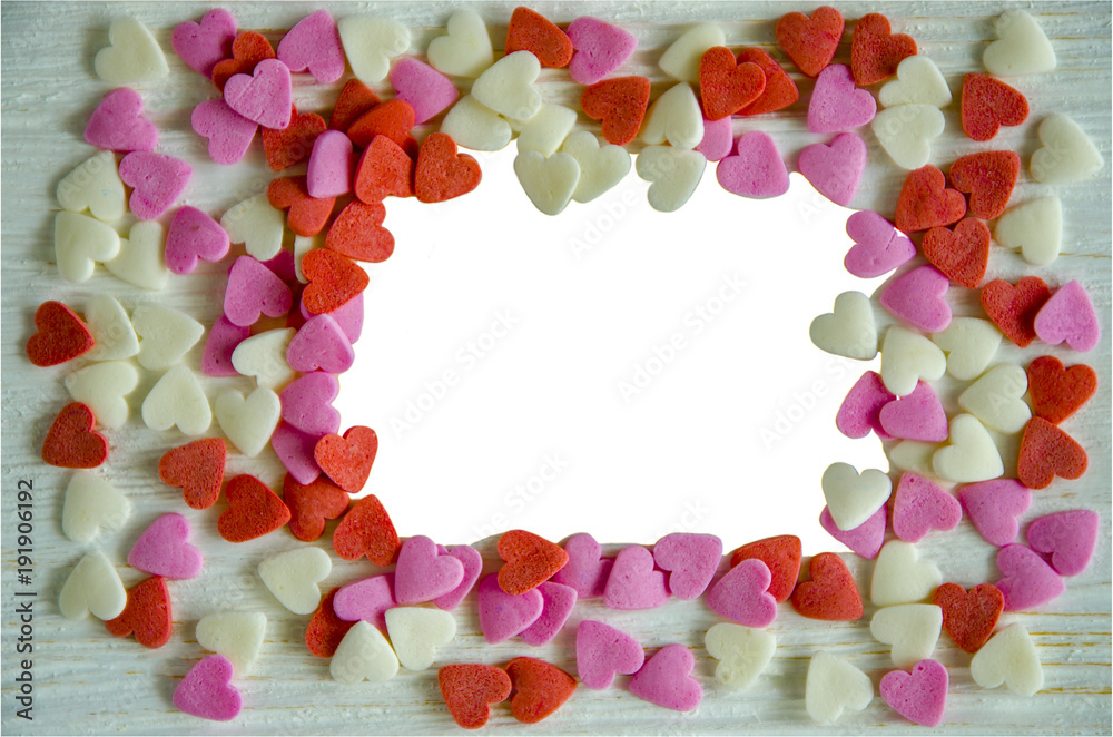 Hearts for photo frame...Colored hearts on a light wooden background. The middle of the photo is an isolate.