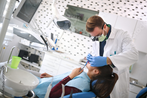 Dentist examine girl's teeth on dental clinic