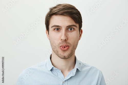 Charming and cute adult man with bristle holding hands in pray or as if begging something while looking at camera with hope and standing over gray background. Student asks teacher give him extra time