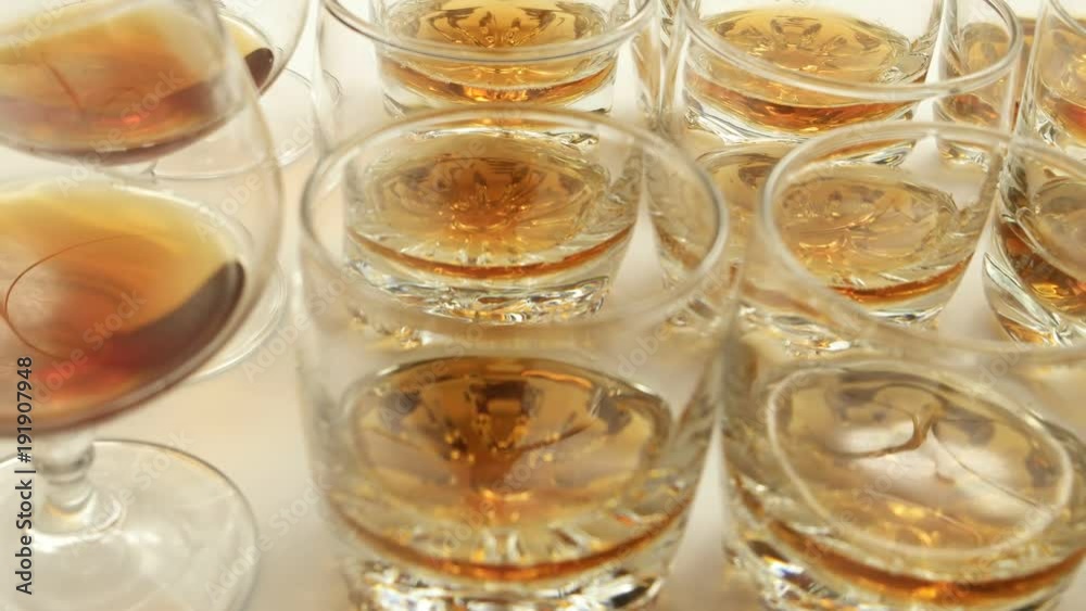 The glasses of beverage move on the surface of the table The glasses of beverage move on the surface of the table