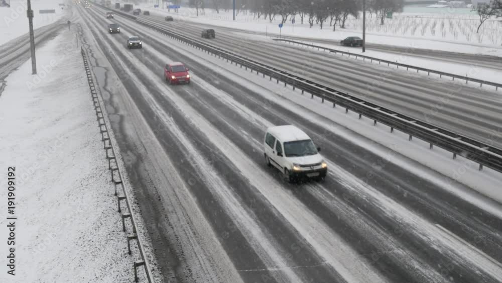 Traffic on highway during winter blizzard. Snowstorm on the road. Traffic on highway during winter blizzard. Snowstorm on the road.