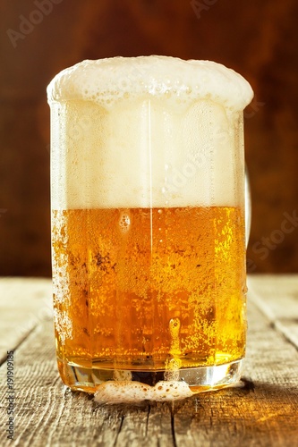 Glass of beer on an old wooden table. Sales of alcohol. Beer advertising.