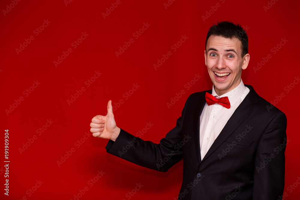 Half body photo of Young Stylish man in suit giving thumb up. Happy man  with arm
