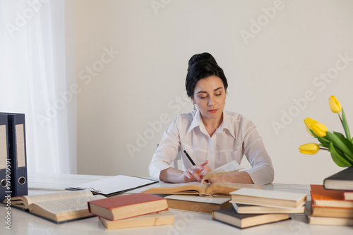 teacher business Lady reads books in the Office