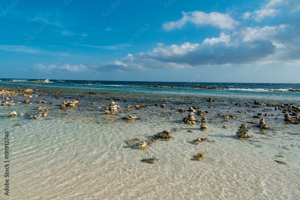 pebble beach and ocean waves on the sea of the Caribbean island of Aruba pebble beach and ocean waves on the sea of the Caribbean island of Aruba