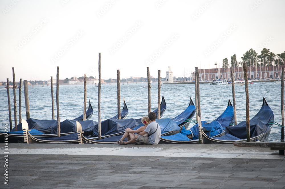 Venice lagoon, Italy with gondolas and embraced couple