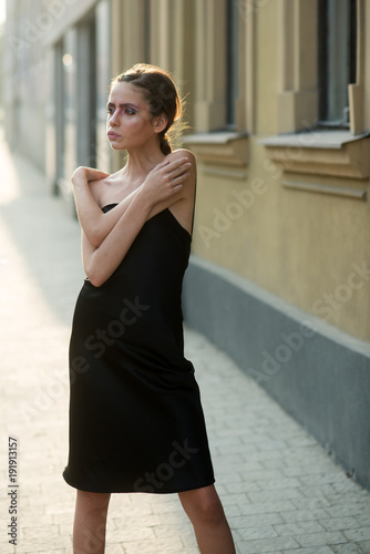 Fashion model in summer dress pose on street sidewalk