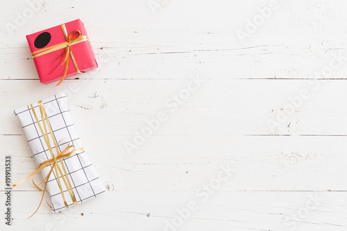 Top view on nice Christmas, birthday or any other celebration presents on white wooden background. Gifts. Holiday season.