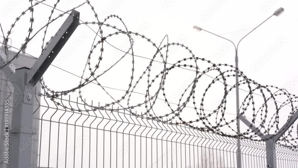 barbed wire on a fence in winter close-up. fencing of a restricted area or prison barbed wire on a fence in winter close-up. fencing of a restricted area or prison