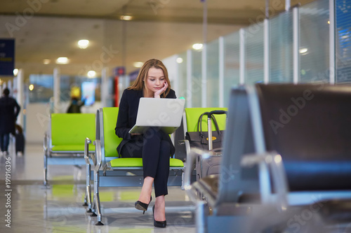 Woman in international airport working on laptop