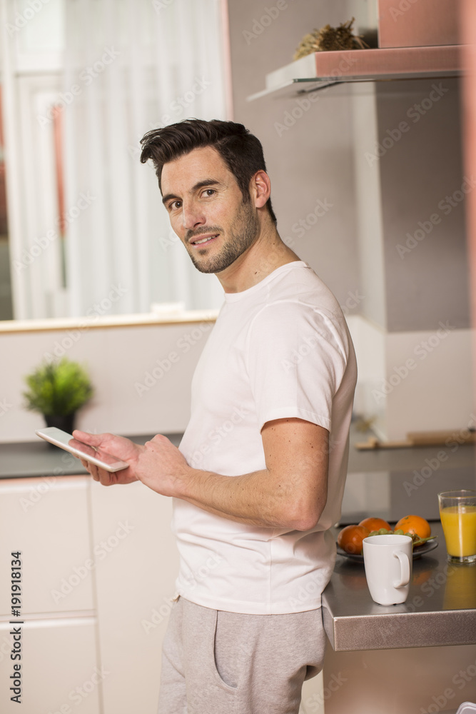 young man in home kitchen with tablet young man in home kitchen with tablet