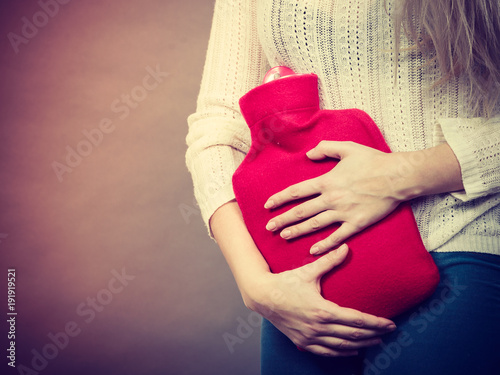 Photography Woman feeling stomach cramps holding hot water bottle