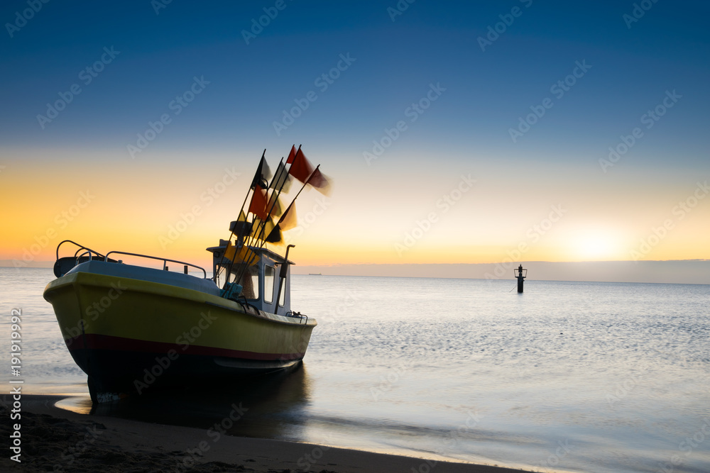 Φωτογραφία The rising sun illuminates the fishing boat. Baltic sea.