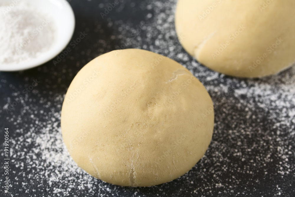 Ungebackener Hefeteig oder Germteig für die Zubereitung von Brot, Brötchen oder Pizza auf bemehlter Fläche, fotografiert mit natürlichem Licht (Selektiver Fokus, Fokus auf die Vorderseite des Teiges) Ungebackener Hefeteig oder Germteig für die Zubereitung von Brot, Brötchen oder Pizza auf bemehlter Fläche, fotografiert mit natürlichem Licht (Selektiver Fokus, Fokus auf die Vorderseite des Teiges)