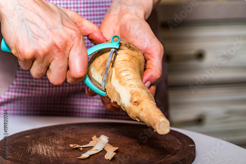 Картината върху платно Hands peeling parsnip close