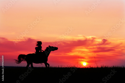 Romantic pink sunset with galloping horse and female silhouette. Horseback riding on rising sun horizon. Arabian horse safari on colorful sunset background. 