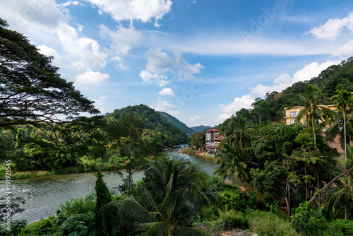 Tropical river view with wooden cottages on bank