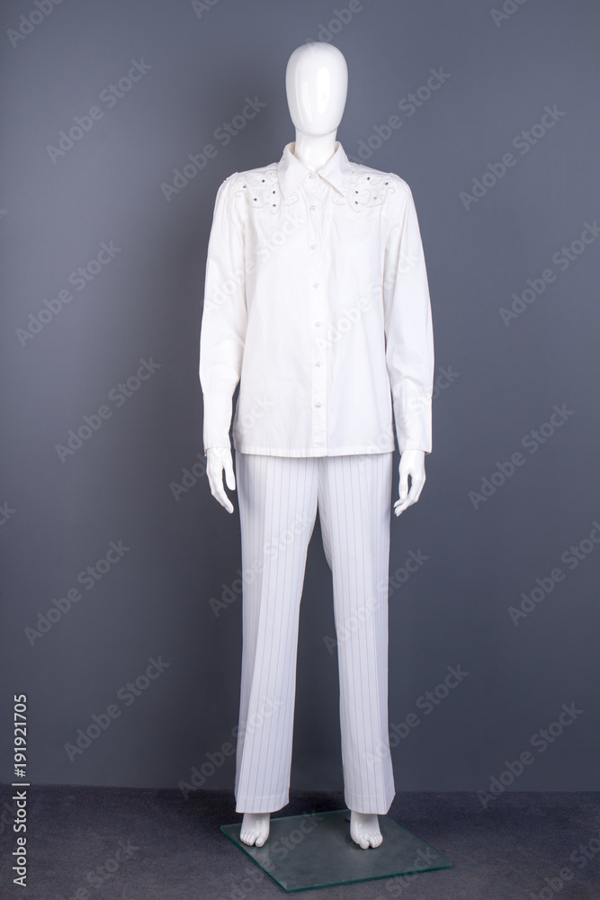 Full length mannequin in white apparel. Women long sleeve blouse and trousers on mannequin. Female garment store. Full length mannequin in white apparel. Women long sleeve blouse and trousers on mannequin. Female garment store.
