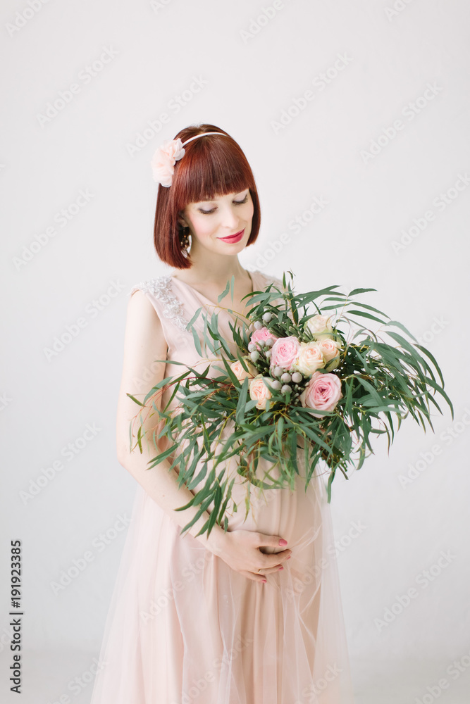 Pregnant girl is standing with large bouquet of flowers Pregnant girl is standing with large bouquet of flowers