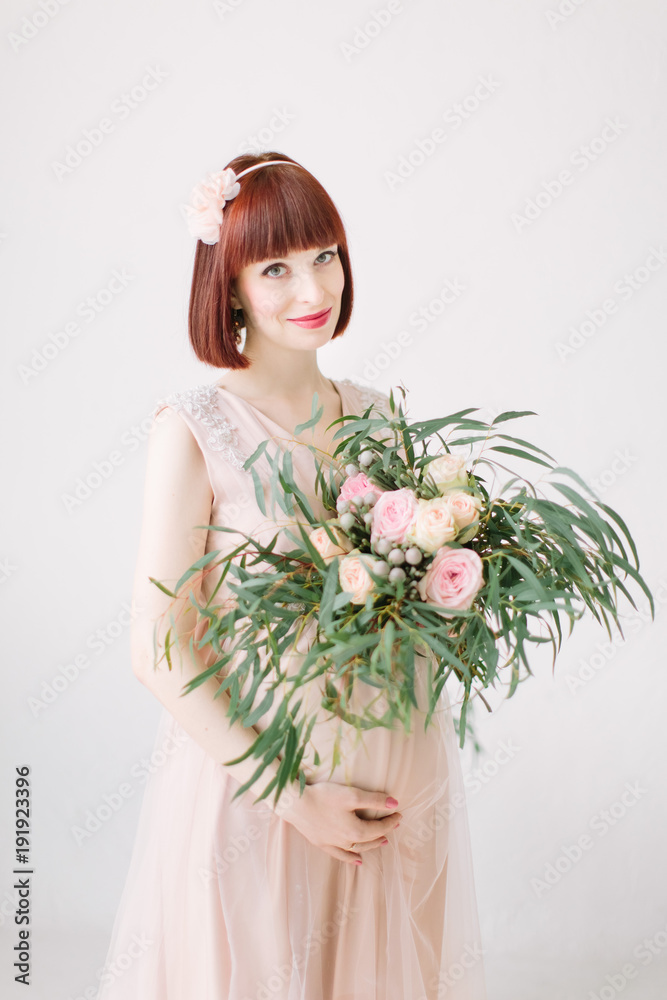Pregnant girl is standing with large bouquet of flowers Pregnant girl is standing with large bouquet of flowers