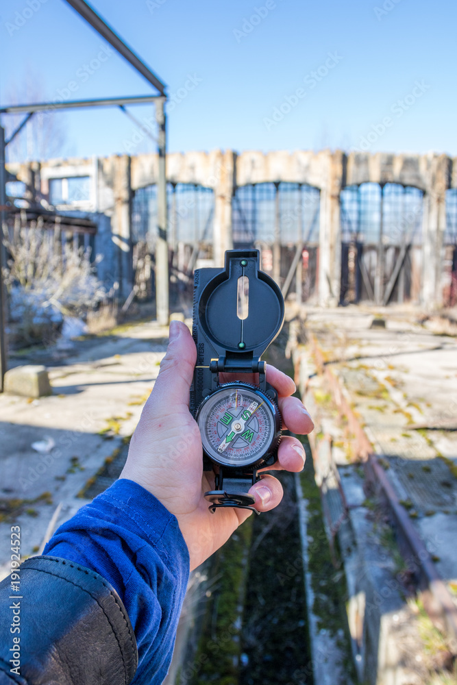 Naklejka premium Mann hält Kompass in Lost Place