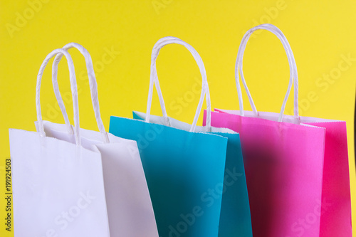 multicolored Shopping bags on yellow background, sale, purchase