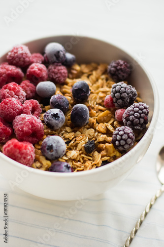 Granola on white wooden background with raspberry and blueberry berries. The concept of a healthy lifestyle, diet, healthy Breakfast