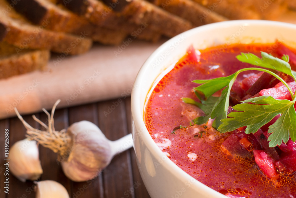 Traditional Ukrainian Russian vegetable soup borscht, with hard cream. parsley rye bread rolls, on black table Traditional Ukrainian Russian vegetable soup borscht, with hard cream. parsley rye bread rolls, on black table