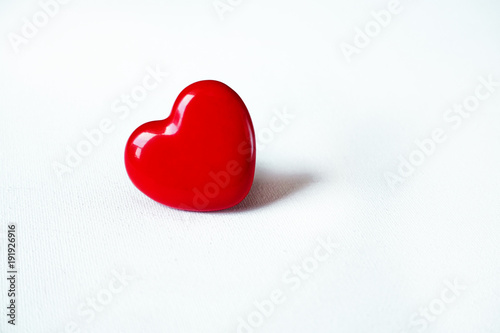 Red heart lying isolated on white surface